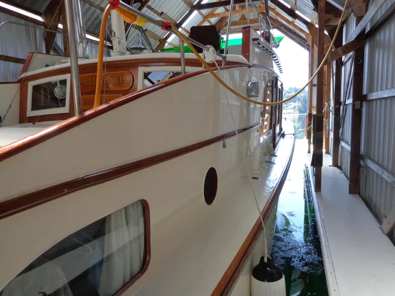 Slide: The Image of 1946 Monk Flybridge Sedan boat docked in a covered marina. - 11