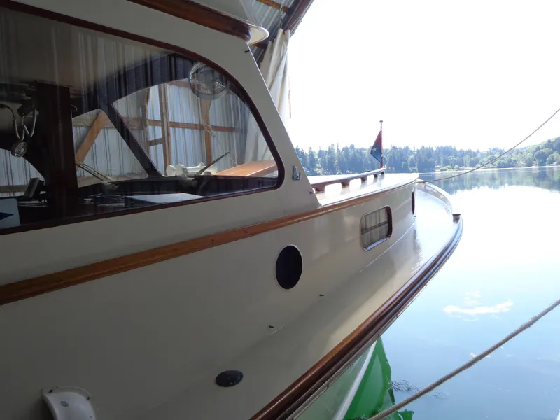 Slide: The Image of 1946 Monk Flybridge Sedan boat docked in a serene lake. - 14