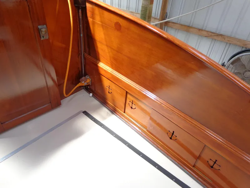 Slide: The Image of 1946 Monk Flybridge Sedan interior with polished wood paneling and anchor-themed drawer handles. - 18