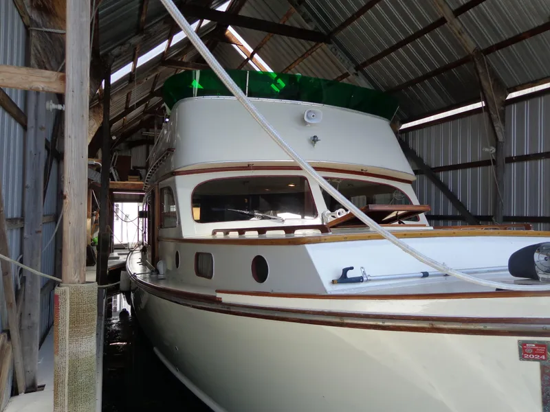 Slide: The Image of 1946 Monk Flybridge Sedan boat docked in a covered marina. - 21