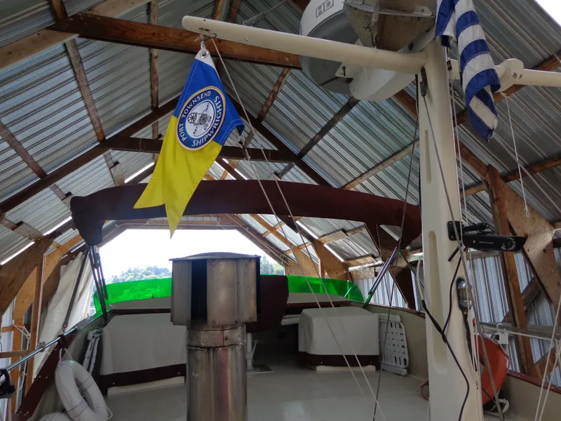 Slide: The Image of 1946 Monk Flybridge Sedan under a metal roof with nautical flags. - 22