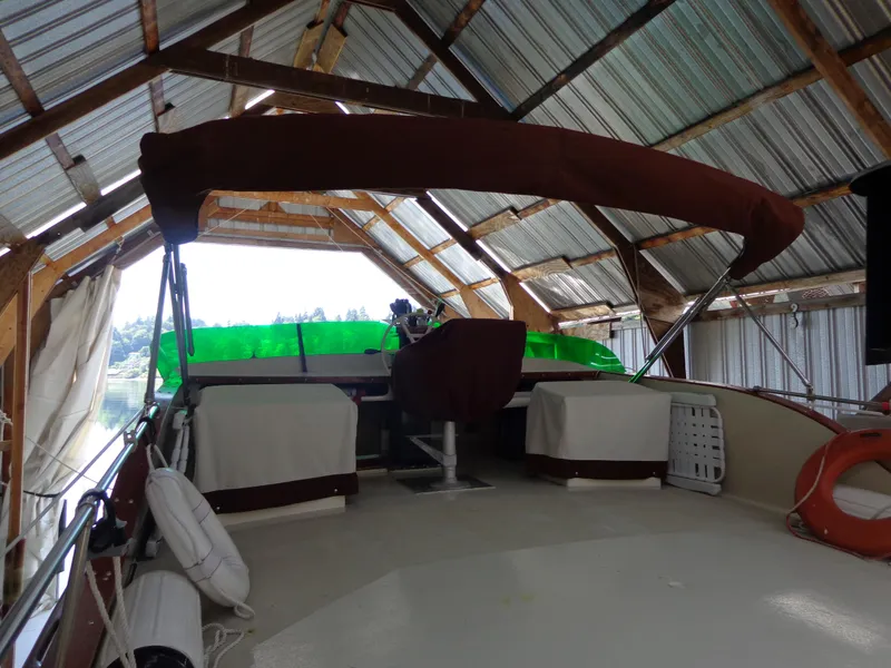 Slide: The Image of 1946 Monk Flybridge Sedan under a metal roofed boathouse. - 24