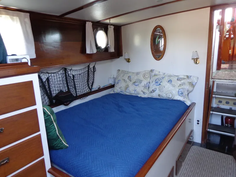 Slide: The Image of 1946 Monk Flybridge Sedan cabin with bed, wooden interior, and nautical decor. - 30