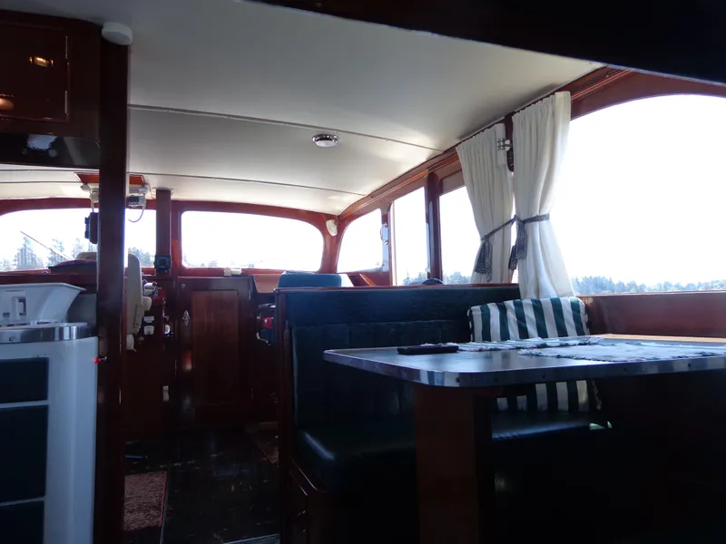 Slide: The Image of Interior of a 1946 Monk Flybridge Sedan boat with dining area and helm station. - 32