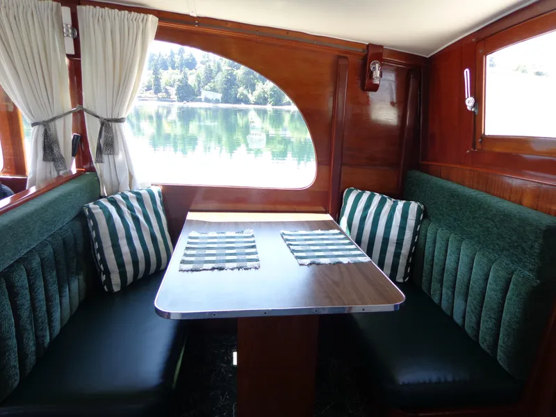 Slide: The Image of 1946 Monk Flybridge Sedan interior with green seating, wooden table, and striped cushions. - 35