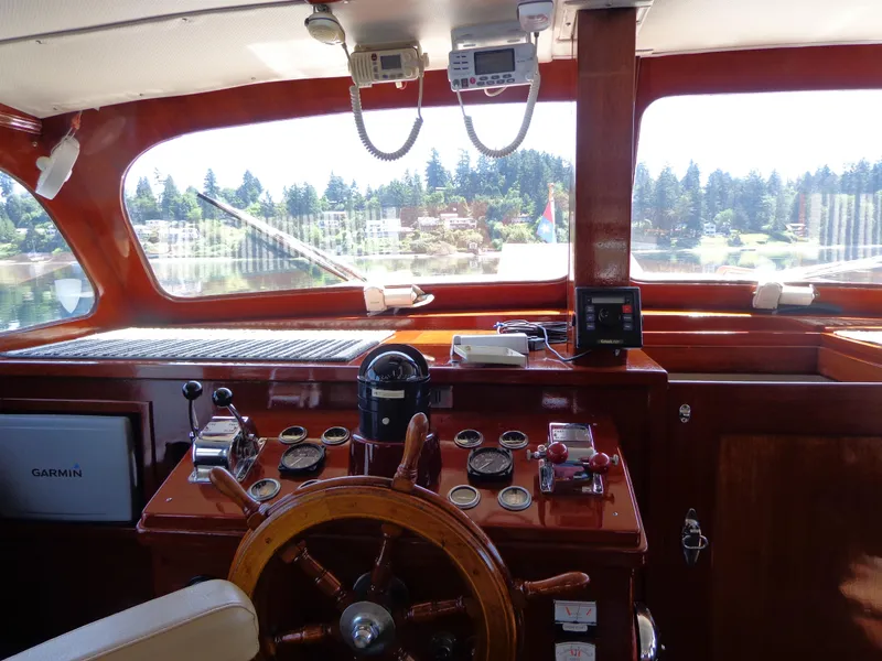 Slide: The Image of 1946 Monk Flybridge Sedan boat helm with wooden steering wheel and navigation instruments. - 40