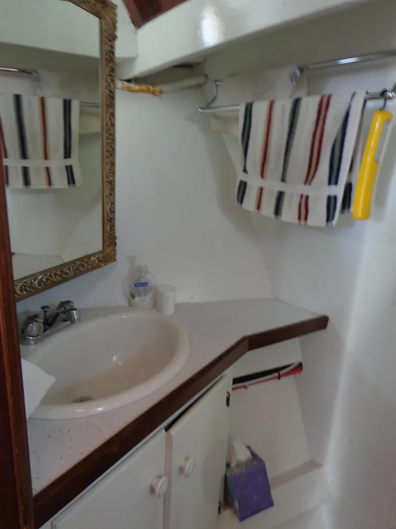Slide: The Image of 1946 Monk Flybridge Sedan bathroom with sink, mirror, and striped towel. - 44