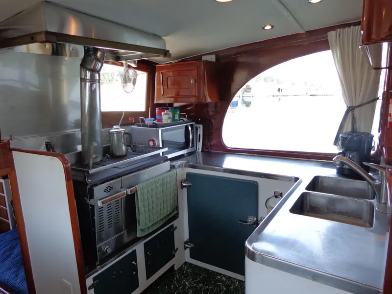 Slide: The Image of 1946 Monk Flybridge Sedan boat kitchen with stainless steel appliances and large window. - 49