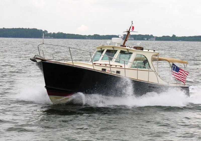 The Image of 2001 Mast & Mallet 38 Picnic Boat cruising on open water with flags flying. - 0
