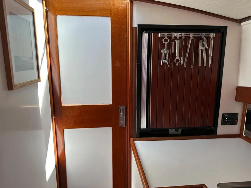 Slide: The Image of Interior of 2001 Mast & Mallet 38 Picnic Boat with wooden door and utensil rack. - 13
