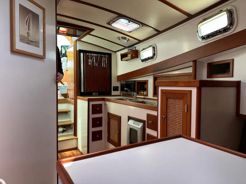 Slide: The Image of Interior of 2001 Mast & Mallet 38 Picnic Boat with wood accents and compact kitchen. - 14