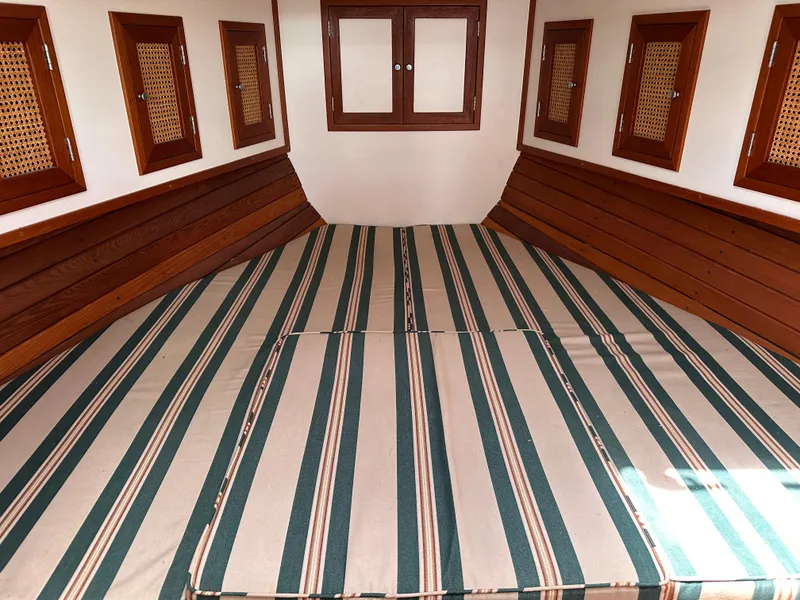 Slide: The Image of Interior cabin of 2001 Mast & Mallet 38 Picnic Boat with striped bedding and wooden accents. - 16