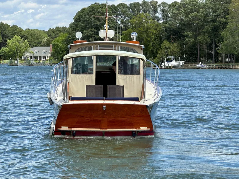 Slide: The Image of 2001 Mast & Mallet 38 Picnic Boat on a serene lake with lush green surroundings. - 23