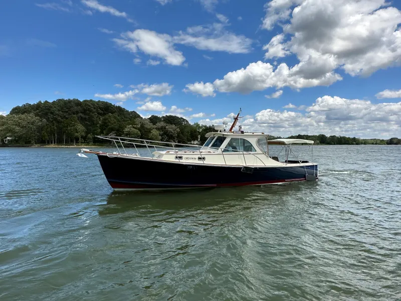 Slide: The Image of 2001 Mast & Mallet 38 Picnic Boat on calm water under a partly cloudy sky. - 26