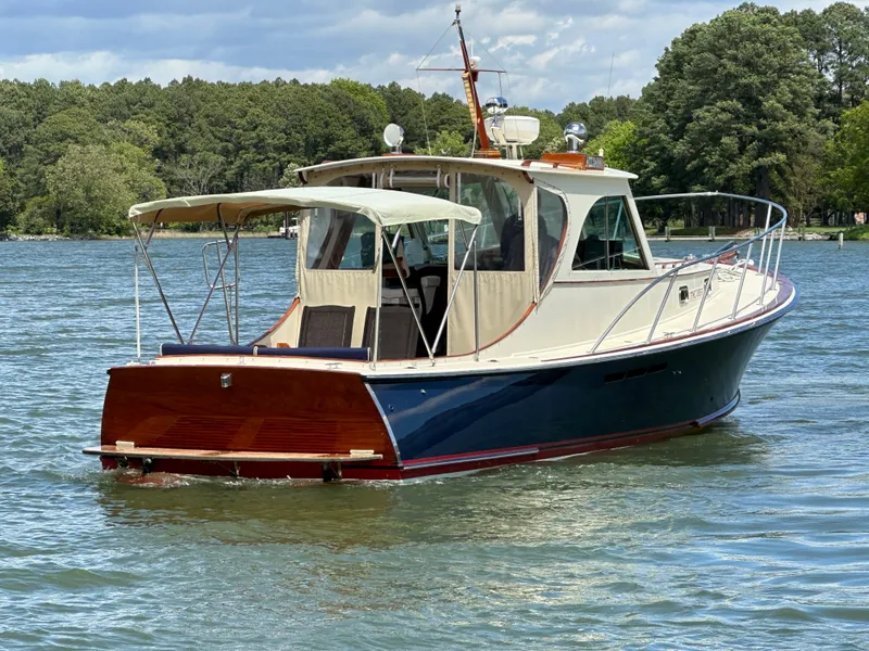 Slide: The Image of 2001 Mast & Mallet 38 Picnic Boat on a serene lake with lush green trees. - 3