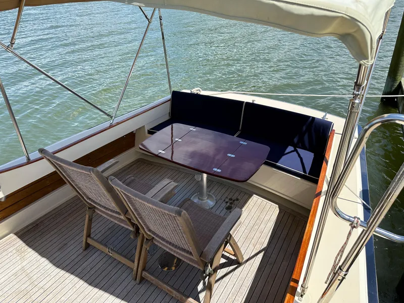 Slide: The Image of 2001 Mast & Mallet 38 Picnic Boat with seating area and table on deck. - 8