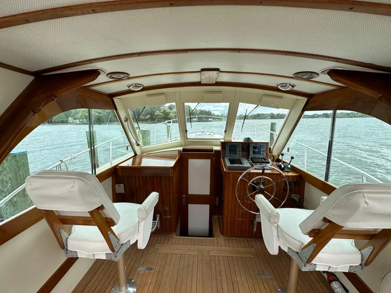 Slide: The Image of Interior view of 2001 Mast & Mallet 38 Picnic Boat with wooden helm and white seats. - 9