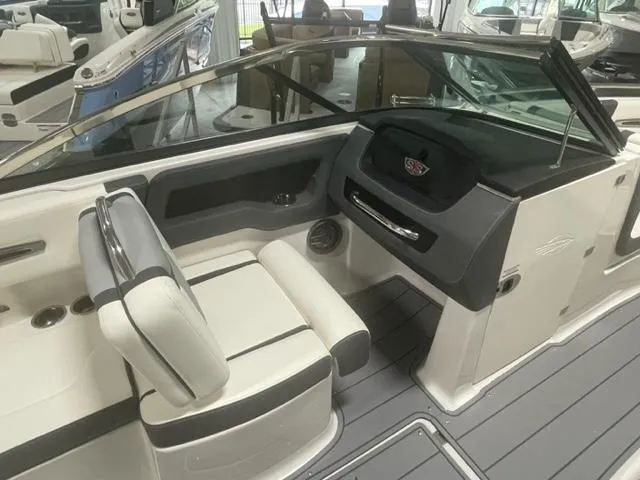 Slide: The Image of 2023 Chaparral 247 SSX boat interior with white and black seating and dashboard. - 10