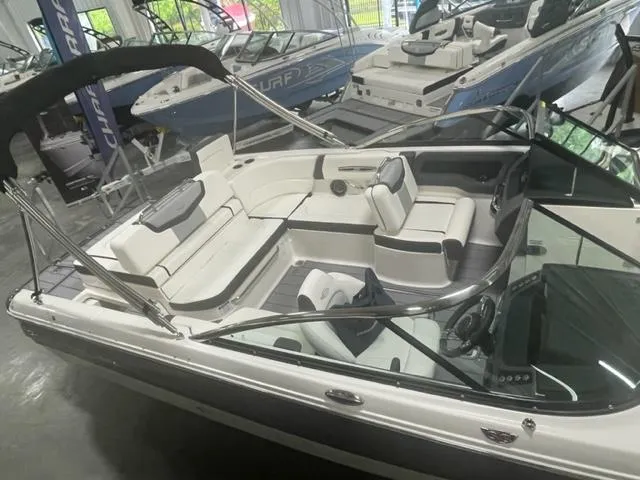 Slide: The Image of 2023 Chaparral 247 SSX boat with spacious seating and sleek design in showroom. - 4