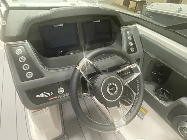Slide: The Image of 2023 Chaparral 247 SSX boat dashboard with dual Simrad displays and steering wheel. - 9