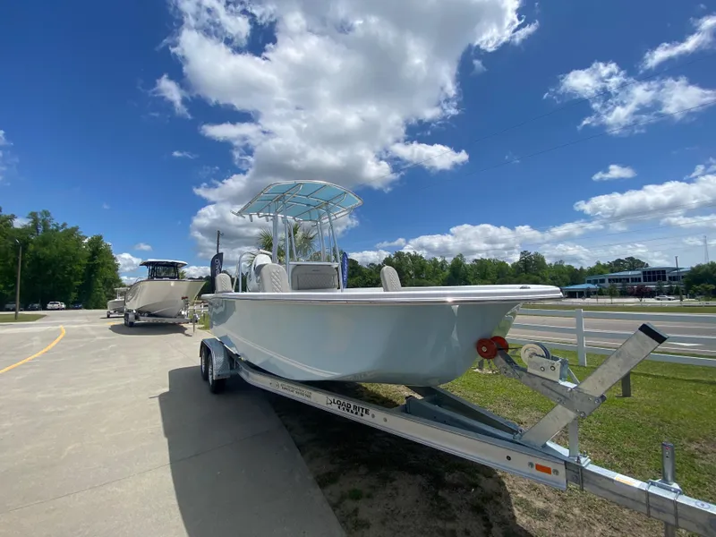 Slide: The Image of 2024 Savannah SS21 boat on trailer under blue sky with clouds. - 2