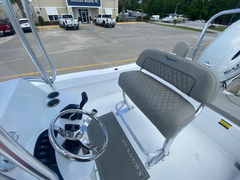 Slide: The Image of 2024 Savannah SS21 boat interior with steering wheel and cushioned seating at Angler's Marine NC. - 7