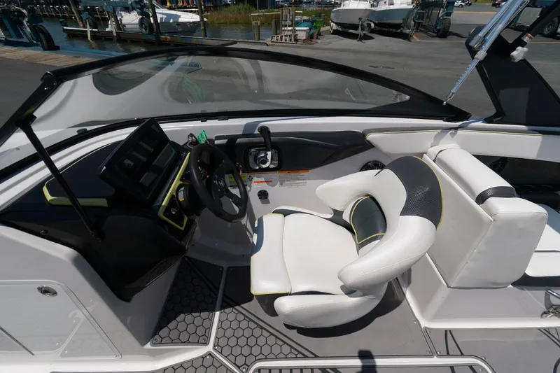 Slide: The Image of 2017 Scarab 255 HO Impulse boat cockpit with steering wheel and white seating. - 10