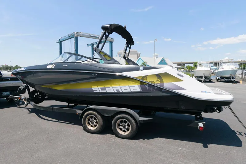 Slide: The Image of 2017 Scarab 255 HO Impulse boat on trailer at marina. - 2