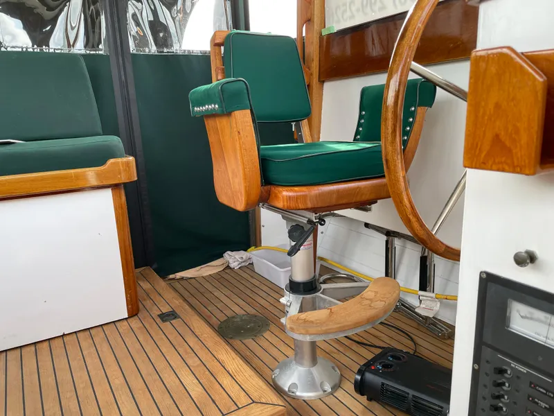 Slide: The Image of 1996 Downeast 36 Lobster Boat helm with green cushioned seat and wooden steering wheel. - 14