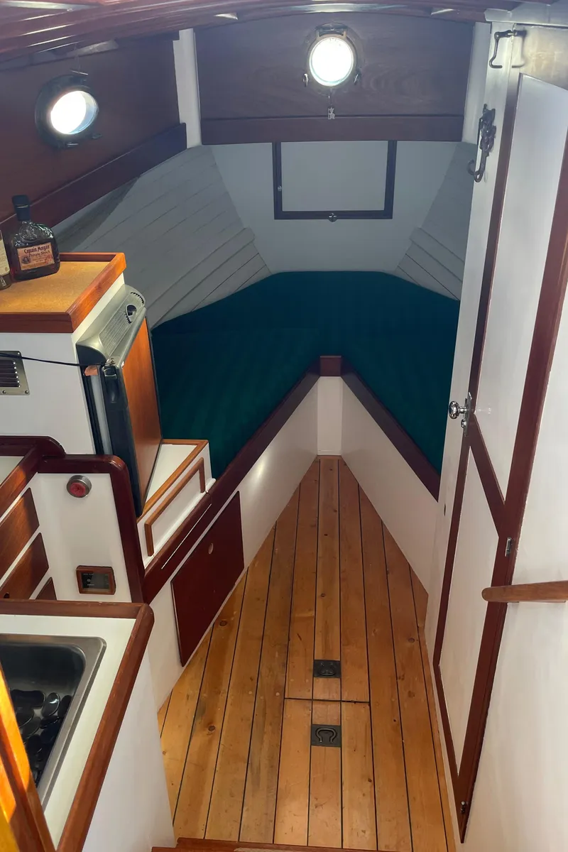 Slide: The Image of Interior of 1996 Downeast 36 Lobster Boat with wooden flooring and compact kitchen area. - 24