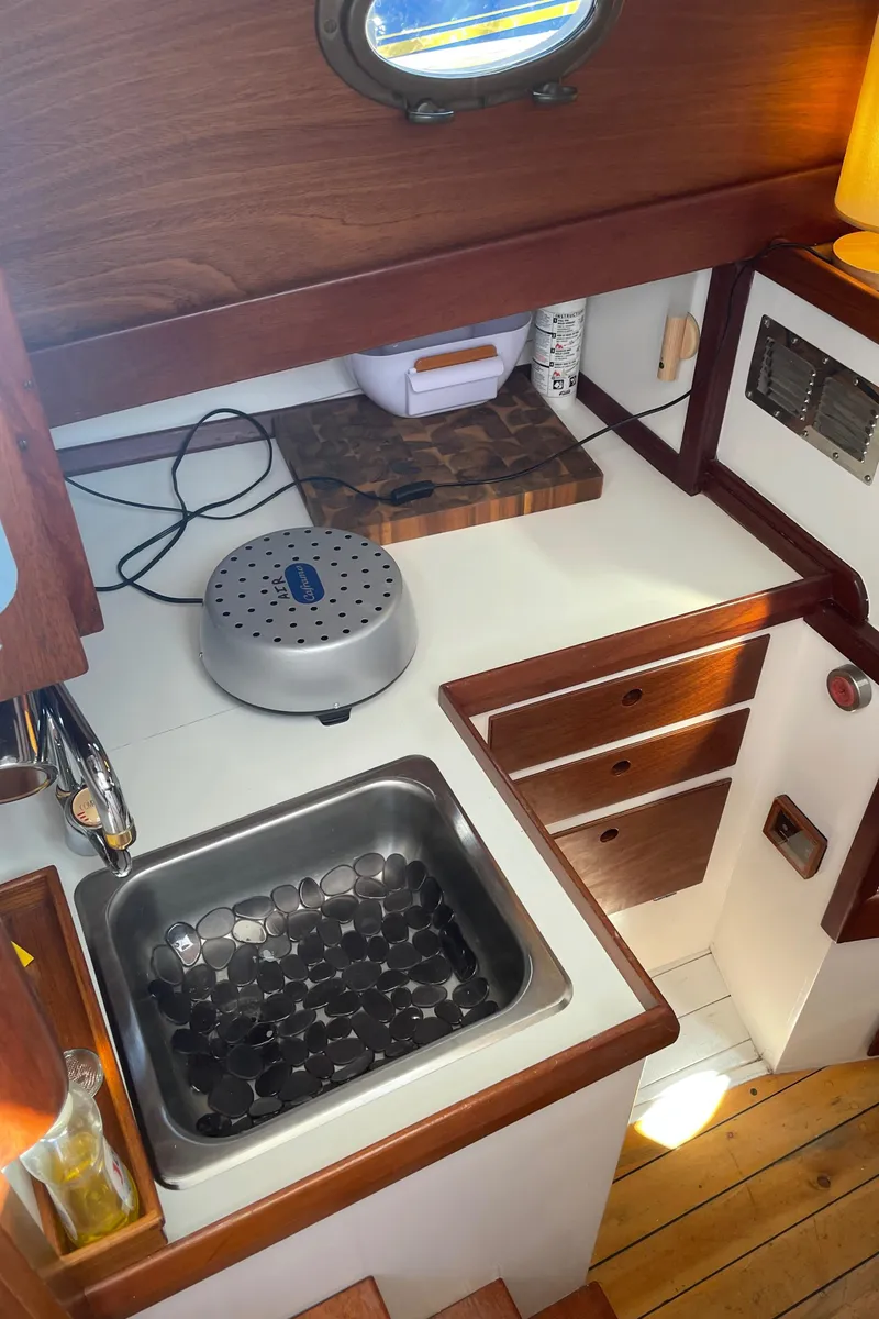 Slide: The Image of 1996 Downeast 36 Lobster Boat galley with sink, wooden cabinets, and countertop. - 25