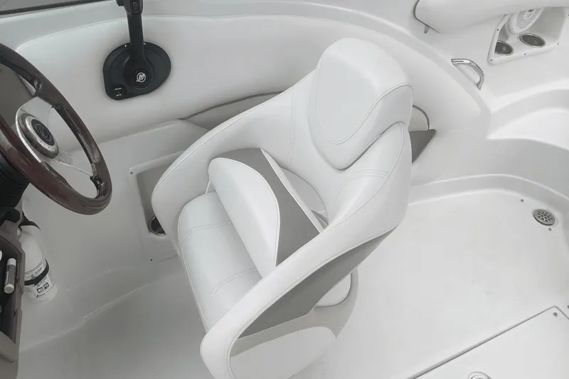Slide: The Image of Interior of 2012 Crownline 265 SS boat, featuring a white captain's chair and steering wheel. - 14