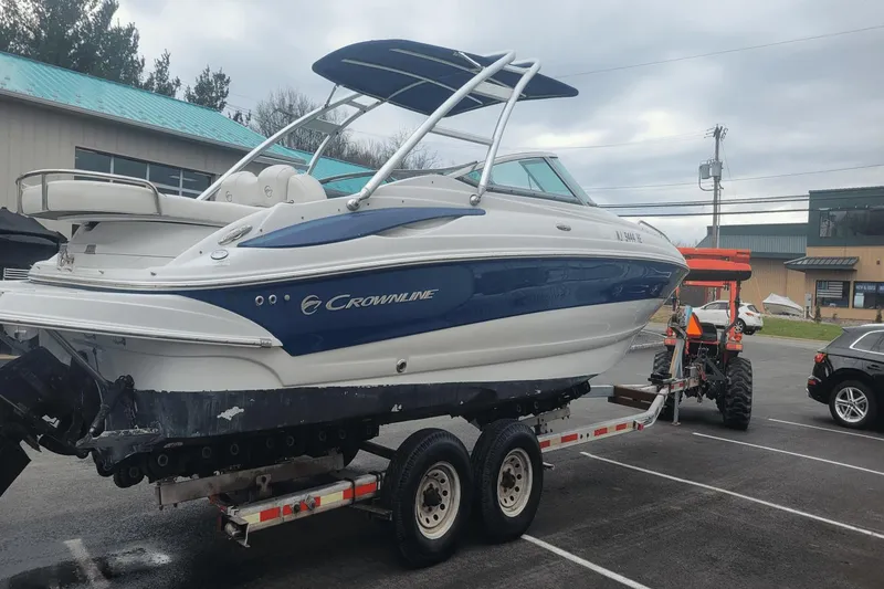 Slide: The Image of 2012 Crownline 265 SS boat on a trailer in a parking lot. - 2