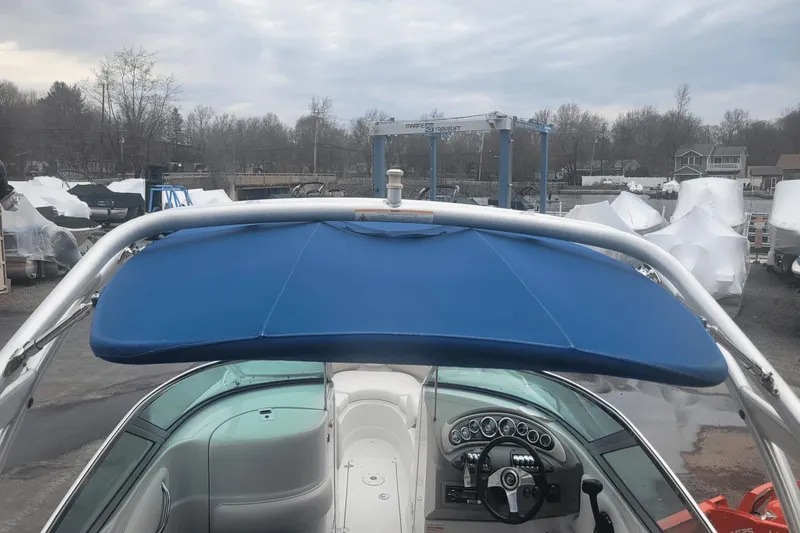 Slide: The Image of 2012 Crownline 265 SS boat with blue bimini top and cockpit view. - 26