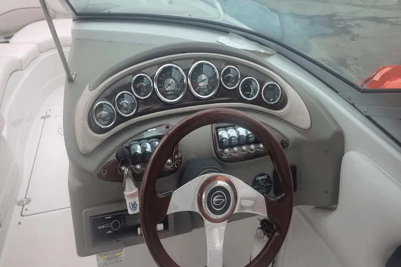Slide: The Image of Dashboard of a 2012 Crownline 265 SS boat with gauges and steering wheel. - 6