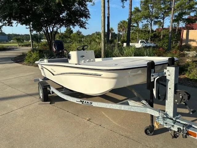 Slide: The Image of 2023 Mako Pro Skiff 13 CC boat on trailer in sunny outdoor setting. - 2