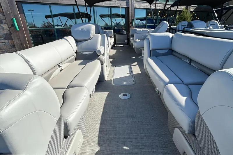 Slide: The Image of 2023 Regency 230 DL3 pontoon boat interior with luxurious seating. - 2