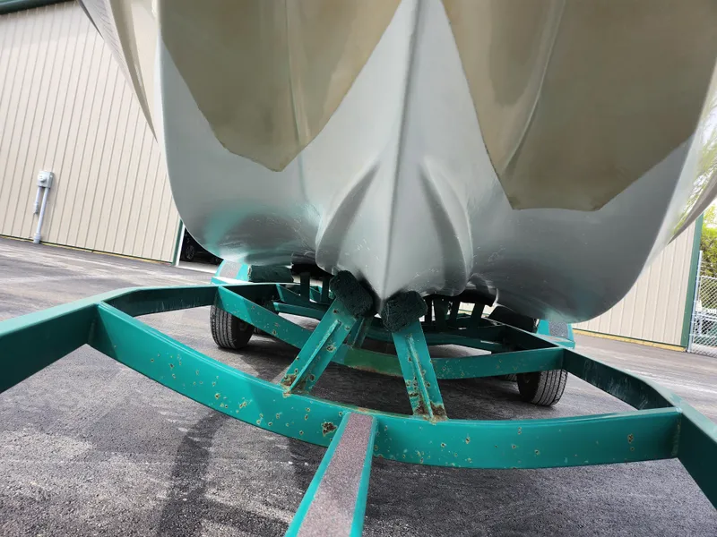 Slide: The Image of 1998 Tigé PRE 2200I boat on a green trailer, close-up view of the hull. - 4