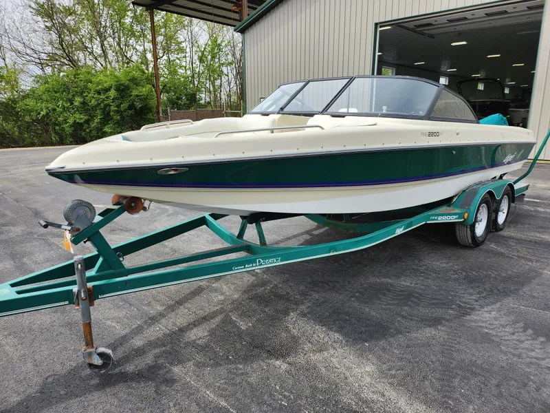 Slide: The Image of 1998 Tigé PRE 2200I boat on a trailer outside a garage. - 5