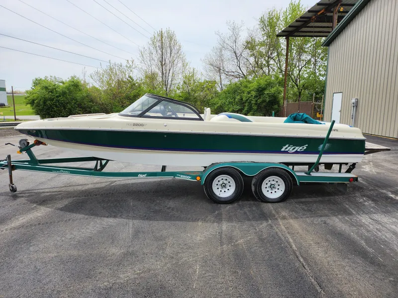 Slide: The Image of 1998 Tigé PRE 2200I boat on a trailer, parked outdoors. - 6