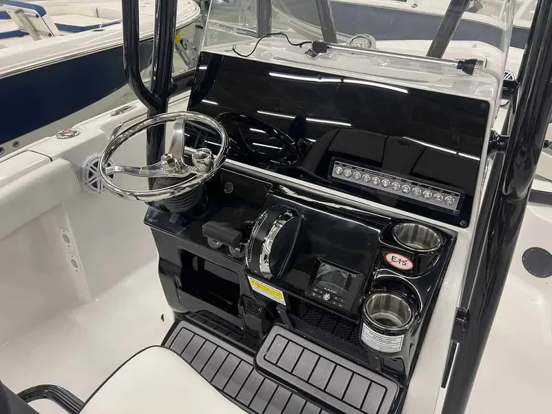 Slide: The Image of 2023 Tidewater 210 Adventure boat console with steering wheel and controls. - 10