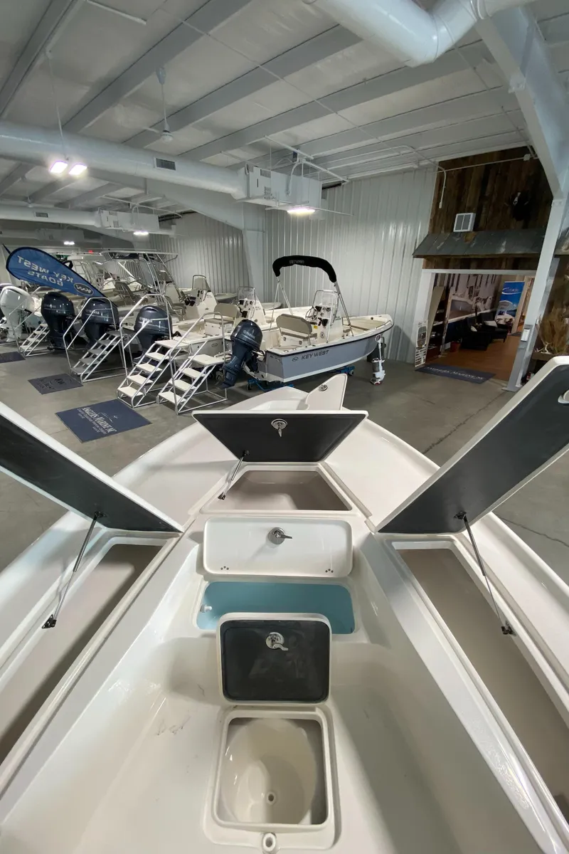 Slide: The Image of 2024 Key West 250 Bay Reef boat on display in a showroom. - 19