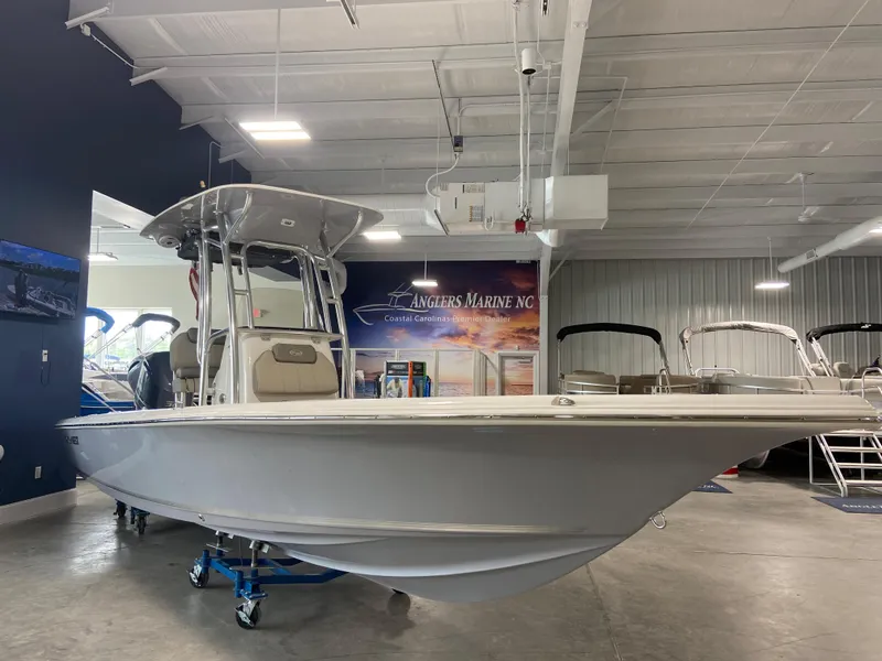 Slide: The Image of 2024 Key West 250 Bay Reef boat displayed in a showroom. - 2