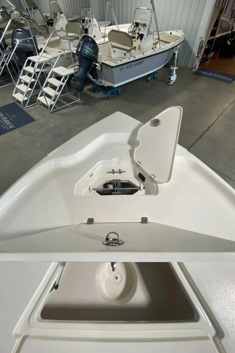 Slide: The Image of 2024 Key West 250 Bay Reef boat interior with open storage compartment. - 21