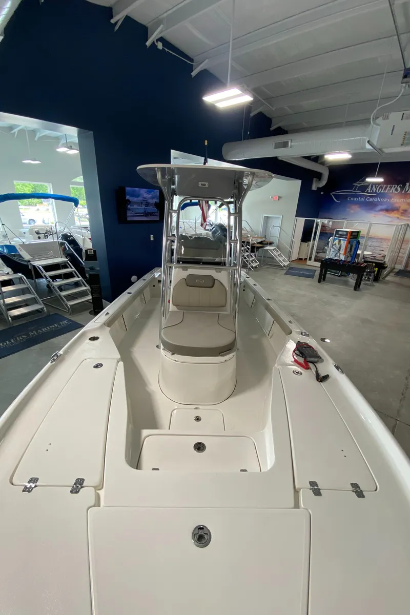 Slide: The Image of 2024 Key West 250 Bay Reef boat displayed in a showroom. - 7