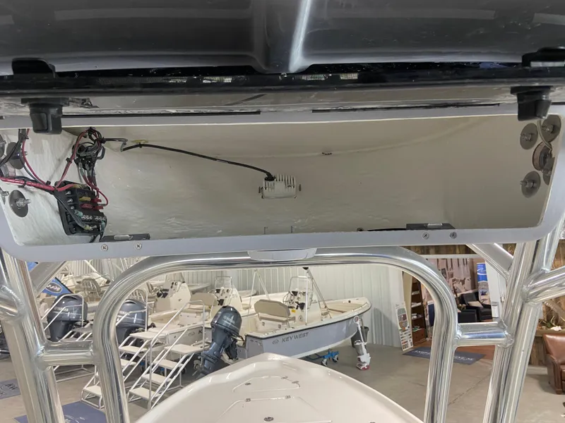Slide: The Image of 2024 Key West 250 Bay Reef boat interior wiring and storage compartment. - 15