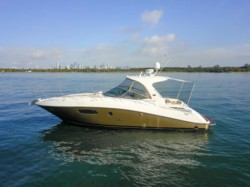 Slide: The Image of 2009 Sea Ray 350 Sundancer yacht on calm water with city skyline. - 0