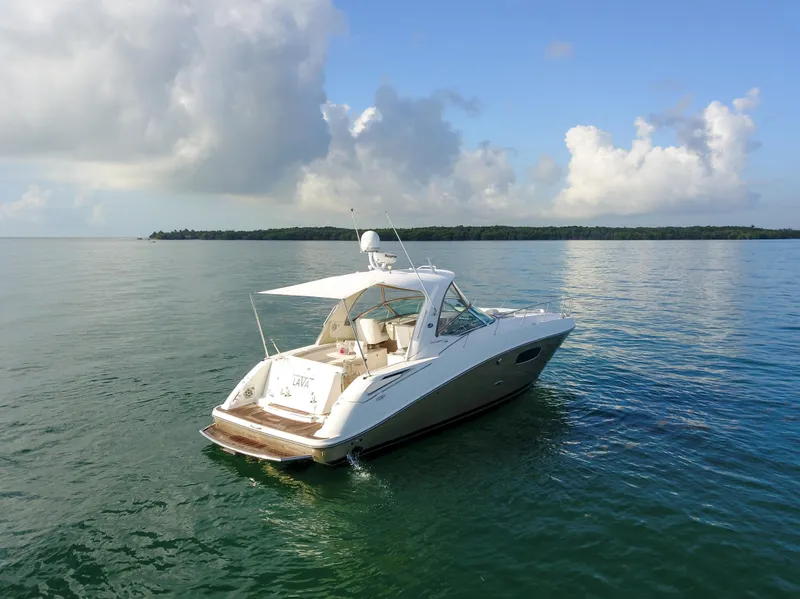 Slide: The Image of 2009 Sea Ray 350 Sundancer yacht on calm waters with scenic background. - 10