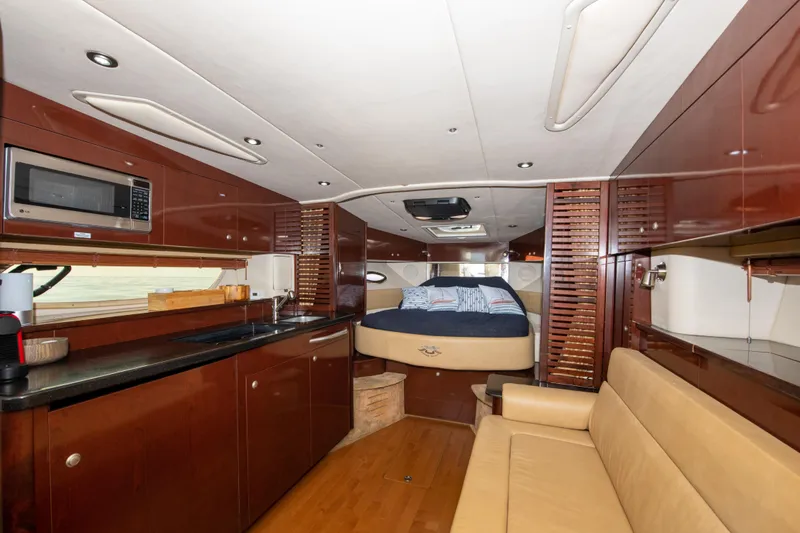 Slide: The Image of Interior of 2009 Sea Ray 350 Sundancer yacht with kitchen, bed, and seating area. - 5