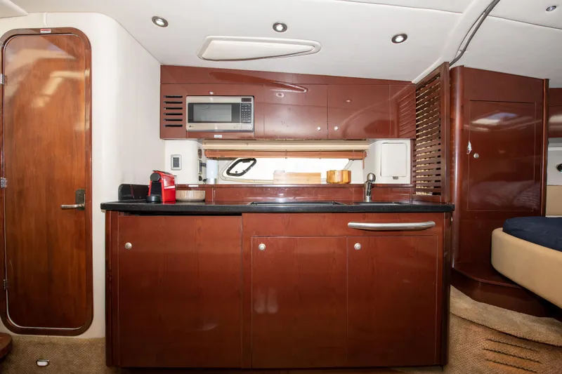 Slide: The Image of Interior kitchen of 2009 Sea Ray 350 Sundancer yacht with microwave and wooden cabinets. - 6